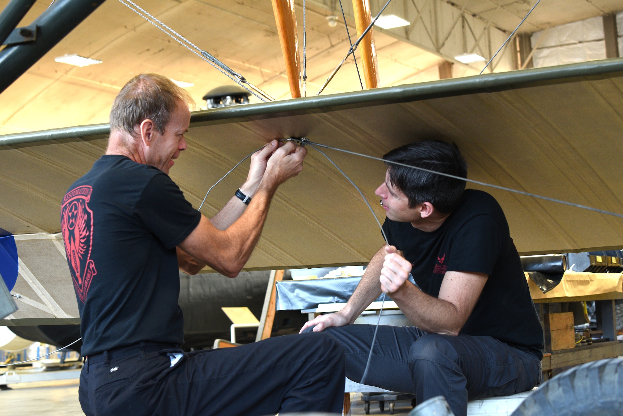 Restoration crew working on biplane wing during restoration.