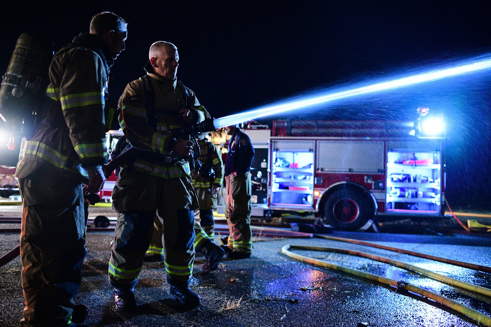 Chief Master Sgt. Christopher Walker, 75th Air Base Wing command chief, operates a hose during a "live fire" with base firefighters Oct. 1, 2019, at Hill Air Force Base, Utah. The fire was part of a Hill AFB Fire and Emergency Services training demonstration to showcase the capability of a new, 100-foot ladder truck the department acquired this summer. (U.S. Air Force photo by R. Nial Bradshaw) (U.S. Air Force photo by R. Nial Bradshaw)
