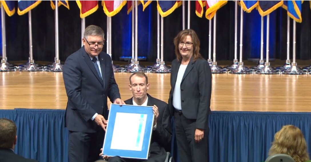 two people pose with award recipient