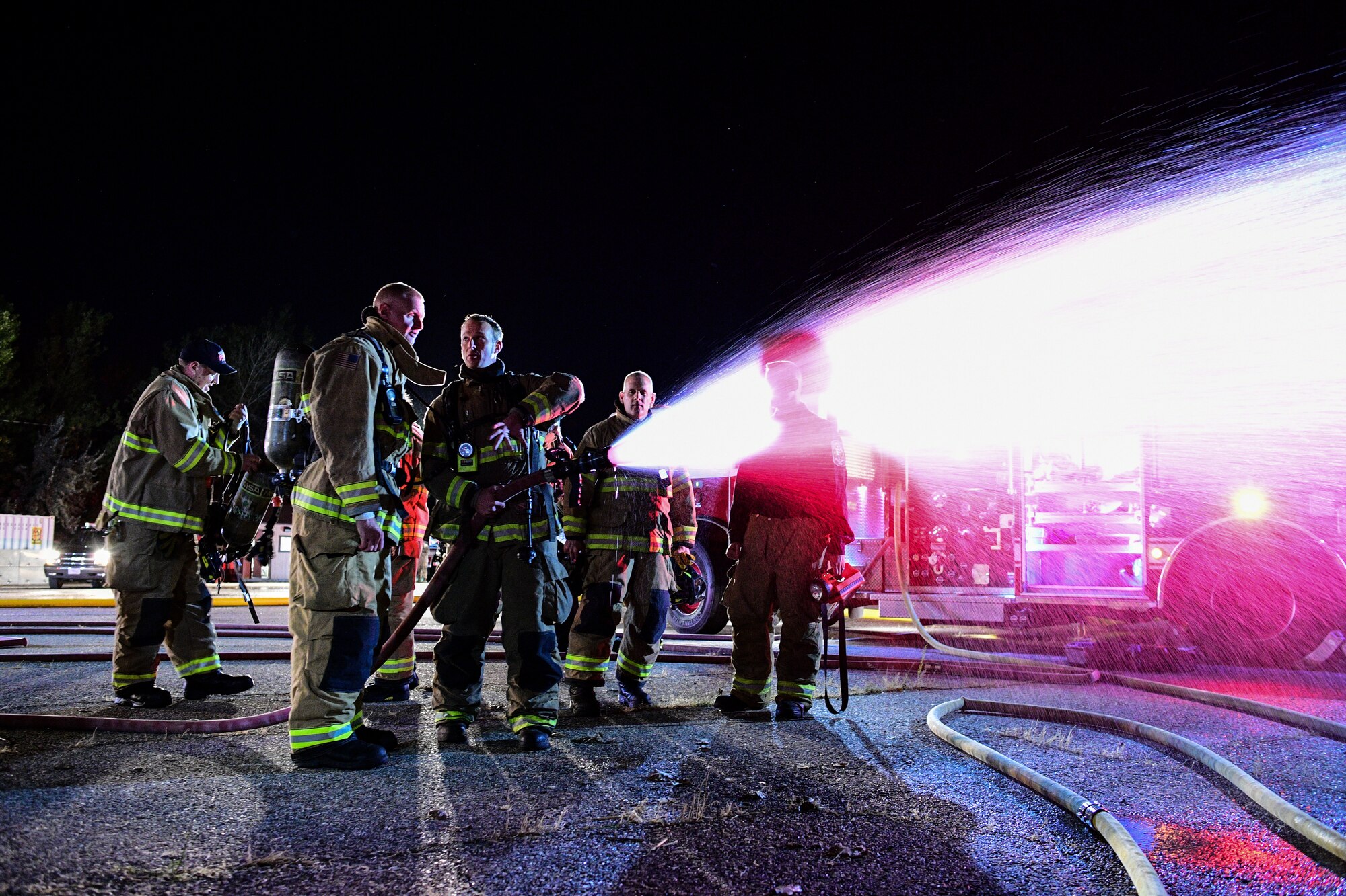 (Front) Col. Jon Eberlan, 75th Air Base Wing commander, learns how to operate a hose during a "live fire" with base firefighters Oct. 1, 2019, at Hill Air Force Base, Utah. The fire was part of a Hill AFB Fire and Emergency Services demonstration to showcase the capability of a new, 100-foot ladder truck the department acquired this summer. (U.S. Air Force photo by R. Nial Bradshaw) (U.S. Air Force photo by R. Nial Bradshaw)