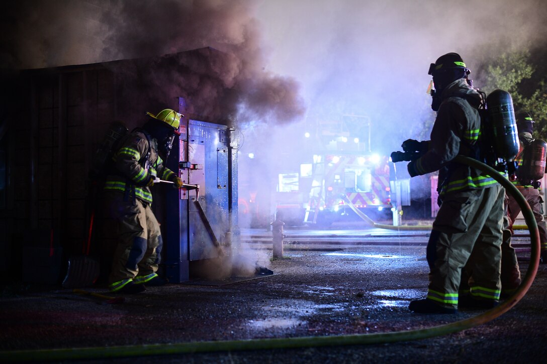 Firefighters prepare to breach the door of a structural fire Oct. 1, 2019, at Hill Air Force Base, Utah. The fire was part of a Hill AFB Fire and Emergency Services training demonstration to showcase the capability of a new, 100-foot ladder truck the department acquired this summer. (U.S. Air Force photo by R. Nial Bradshaw)