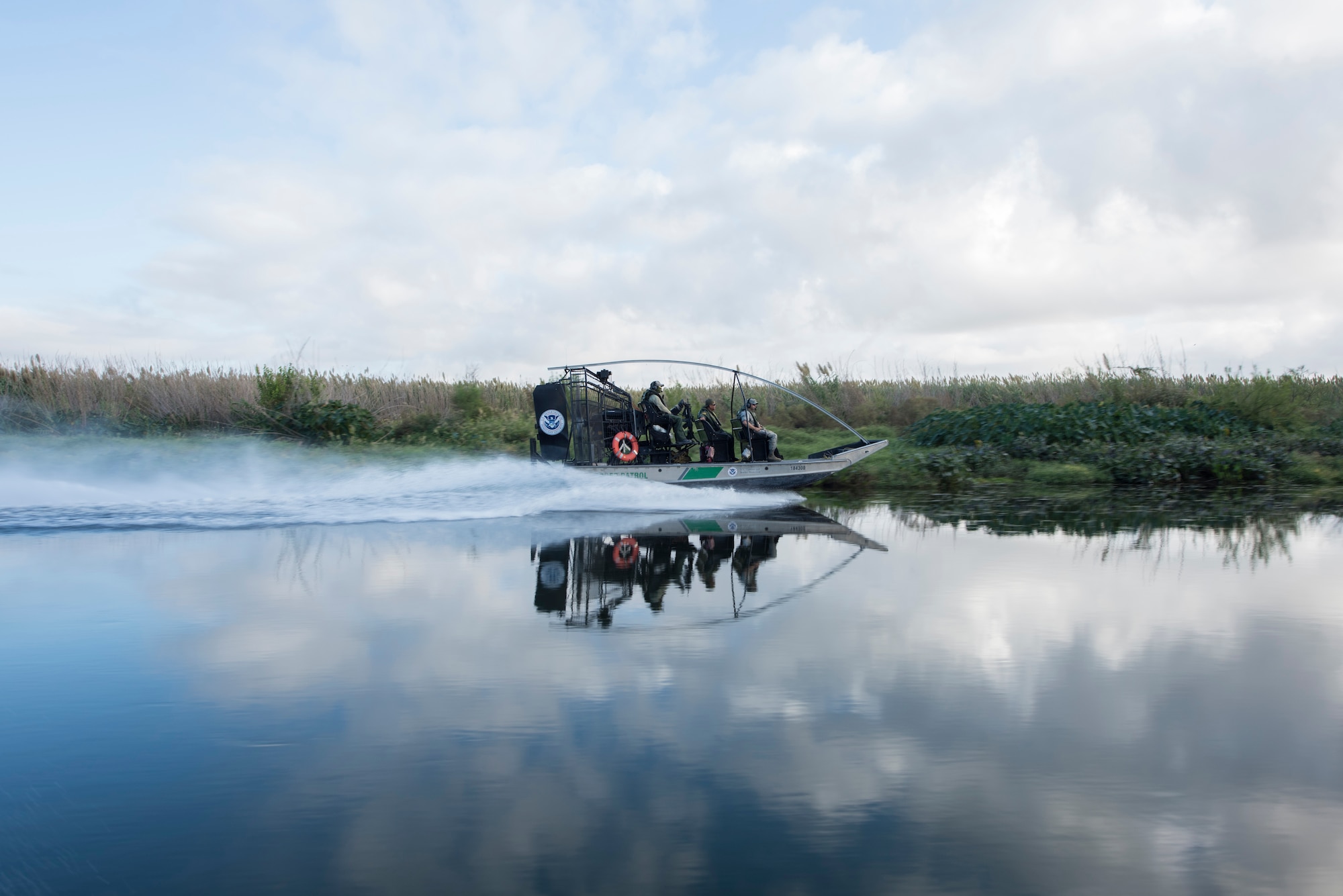 The U.S. Border Patrol tour group rides in a diamondback air boat Oct. 4, 2019 in Del Rio, Texas. The command team got a tour with Del Rio Border Patrol Sector on the Rio Grande river, which marks a portion of the international border between the U.S. and Mexico. (U.S. Air Force photo by Senior Airman Marco A. Gomez)