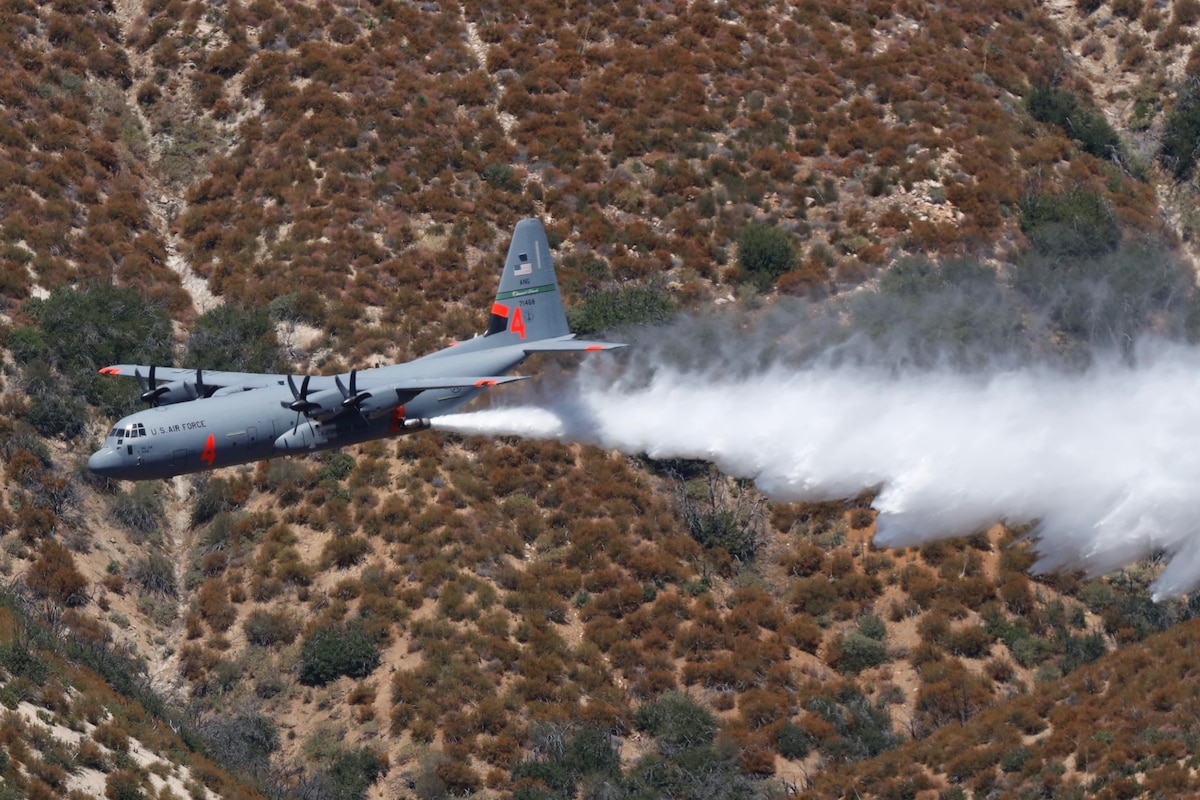 A C-130J aircraft retrofitted with the Modular Airborne Fire Fighting System (MAFFS)  performs a water drop during a training exercise at the Los Padres National Forest north of Santa Clarita, CA. Aug. 24, 2019. (U.S. Air National Guard photo by Senior Airman Todd Senff.)