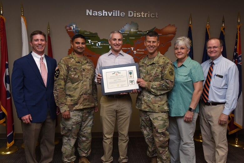 (Left to right) Joseph M. Savage, USACE Great Lakes and Ohio River Division Regional Business director; Lt. Col. Sonny B. Avichal, U.S. Army Corps of Engineers Nashville District commander; Adam Walker, Chickamauga Lock Replacement Project manager; Maj. Gen. Robert F. Whittle Jr., USACE Great Lakes and Ohio River Division commanding general; Patty Coffey, Nashville District deputy district engineer; and Stephen G. Durrett, Programs director; pose during an award ceremony Oct. 2, 2019 at the Nashville District Headquarters in Nashville, Tenn. Whittle presented Walker with the U.S. Army Civilian Service Commendation Medal for managing the Joint Risk Register Pilot Program, an effort to reduce safety risk and identify opportunities for improvement. (USACE photo by Lee Roberts)