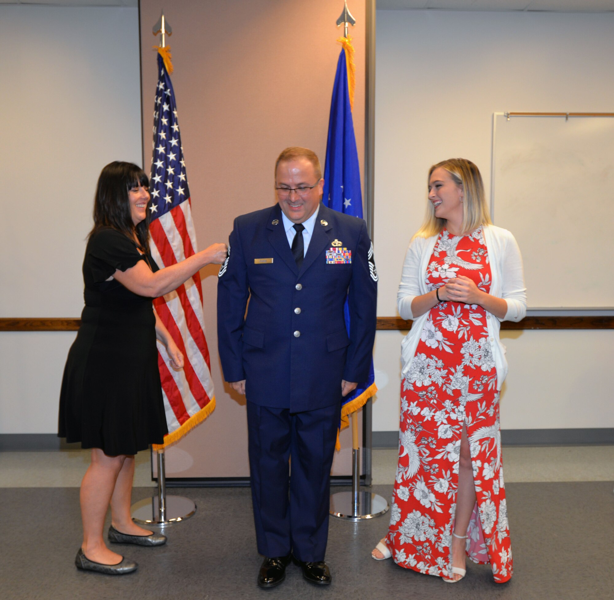 Janie Purvis “pins” new chief master sergeant stripes onto her husband Steven N. Purvis, 74th Aerial Port Squadron superintendent of programs, while his daughter Haleigh watches during a promotion ceremony Oct. 5, 2019 at Joint Base San Antonio-Lackland, Texas.