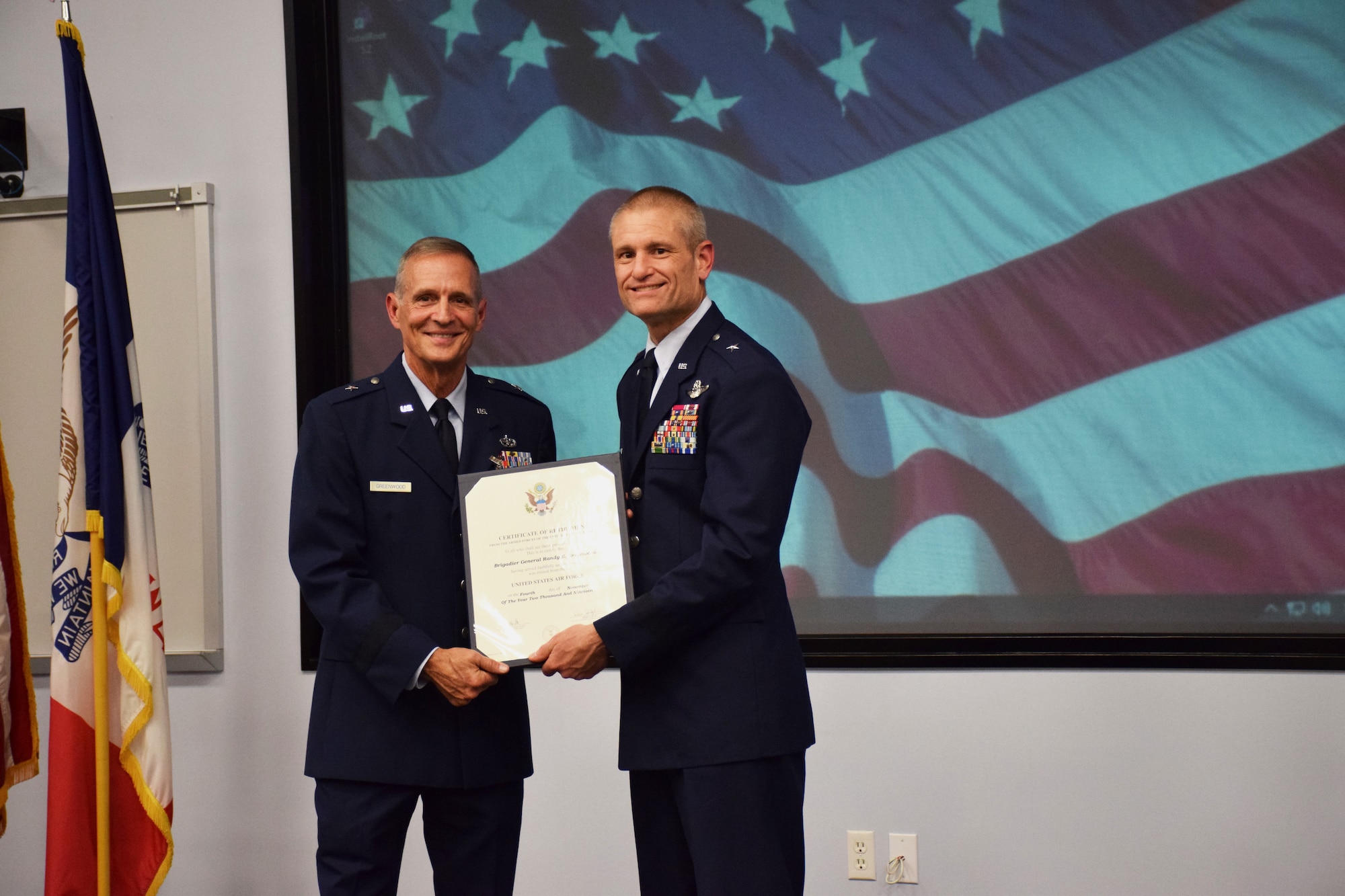 Brig. Gen. Shawn Ford (right), Deputy Adjutant General for Air, Iowa National Guard (IA ANG) presents Brig. Gen. Randy Greenwood (left), Chief of Staff, IA ANG, with his certificate of retirement at his retirement ceremony held in the Enhanced Classroom of Joint Force Headquarters in Johnston, Iowa on Saturday, October 5, 2019.  Greenwood is retiring after thirty-six years of service.  (U.S. Air National Guard photo by Tech. Sgt. Linda K. Burger/Released)