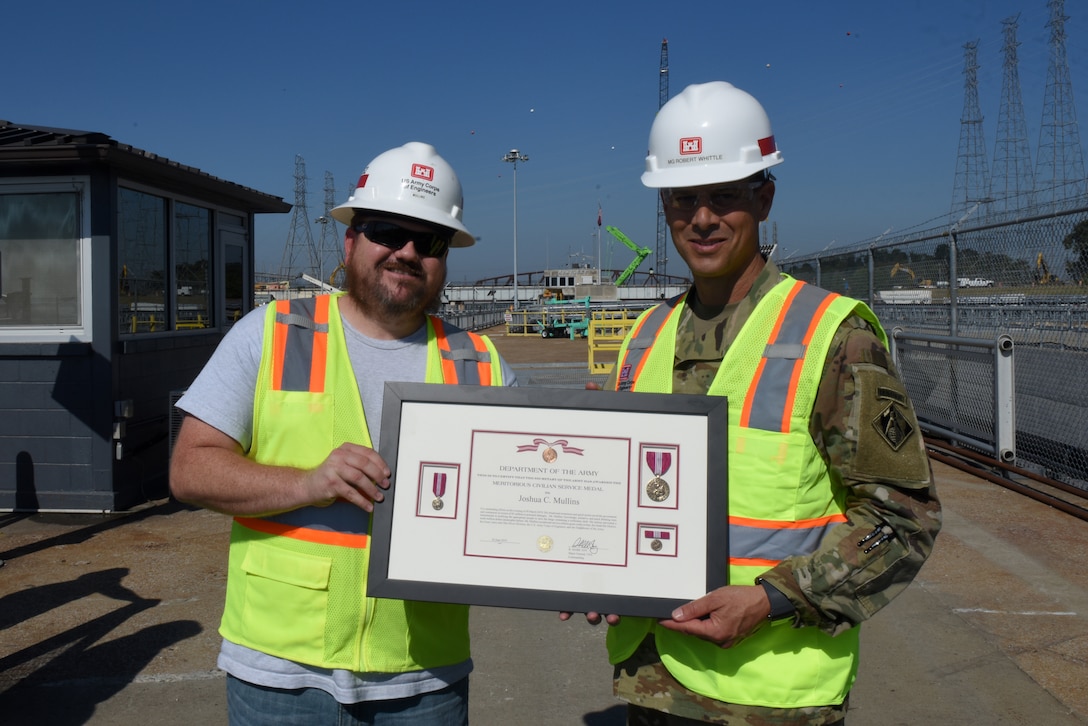 Maj. Gen. Robert F. Whittle Jr., USACE Great Lakes and Ohio River Division commanding general; presents the U.S. Army Meritorious Civilian Service Medal to Lock Operator Joshua C. Mullins at Kentucky Lock in Grand Rivers, Ky., Oct. 3, 2019. Mullins is recognized for preventing $5 million in potential damage when he observed a barge listing on the shoreline of Kentucky Lake and taking action to prevent the loss of a concrete shell used to construct a coffer dam and permanent lock wall as part of the Kentucky Lock Addition Project. (USACE photo by Lee Roberts)