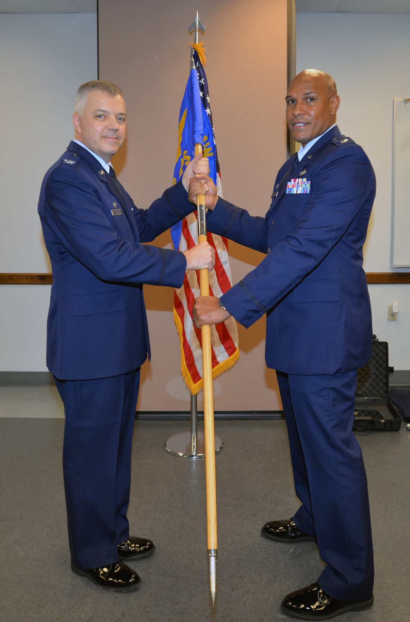 Col. Wayne M. Williams, 433rd Mission Support Group commander, hands the 26th Aerial Port Squadron guidon to Lt. Col. Eric L. Chancellor signaling his squadron command assumption.