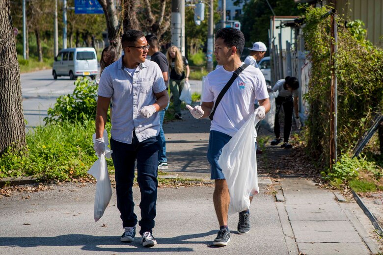 海兵隊員と地元の男性が清掃活動の道中、会話を交わしています。沖縄県うるま市にある米海兵隊基地キャンプ・コートニー独身隊員の会（日本の青年会のような自治会）では毎月うるま市内の清掃活動を実施していて、１０月５日（土）の朝にも日米のボランティアが仲良く清掃活動を行いました。