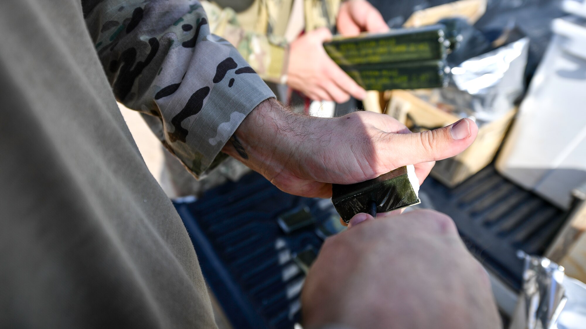 U.S. Air Force Capt. Nicholas Dejulio, 386th Expeditionary Civil Engineer Squadron explosive ordnance disposal flight commander, and Tech. Sgt. Shane Bridges, 386th ECES explosive ordnance disposal craftsman, punch a hole into a C4 block before a rapid airfield damage repair exercise at Udari Range, Kuwait, Sept. 25, 2019. EOD technicians punch holes into high explosives to insert blasting caps, which are used to trigger the explosives