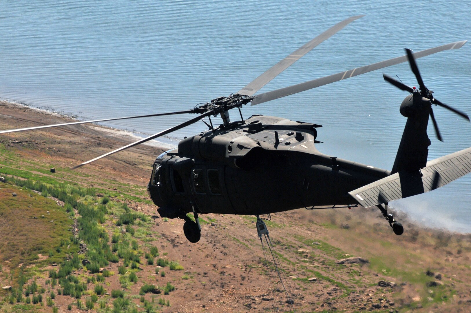 In this stock photo from 2015, a Nevada Army National Guard helicopter flies over Stampede Reservoir in the Sierra Mountain range in northern California. A Nevada Army Guard Black Hawk crew rescued a motorcyclist stranded in a storm Sept. 27, 2019, near Denio, Nevada, about 30 miles south of the Oregon border.