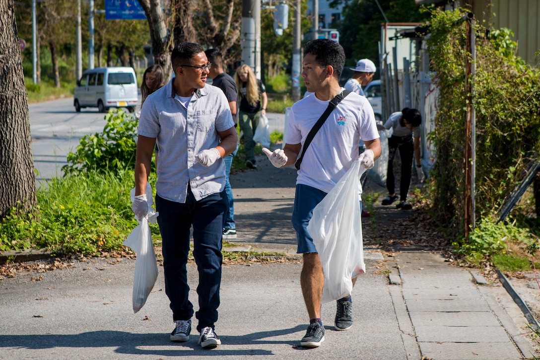 A U.S. Marine and a member of the local community converse during the monthly Friendship Cleanup in Uruma City, Okinawa, Japan on Oct. 5.