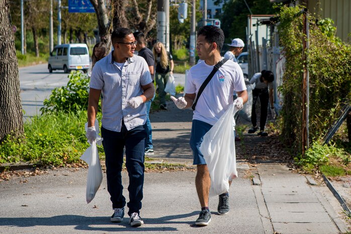 A U.S. Marine and a member of the local community converse during the monthly Friendship Cleanup in Uruma City, Okinawa, Japan on Oct. 5.