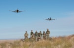 A pair of A-10 Thunderbolt IIs assigned to the 190th Fighter Squadron flies over a group of Airmen from the 124th Fighter Wing at the Saylor Creek Bombing Range, Idaho, Oct. 5, 2019. The range provides a designated area for pilots, Tactical Air Control Party Airmen and other mission-essential groups to run training missions.