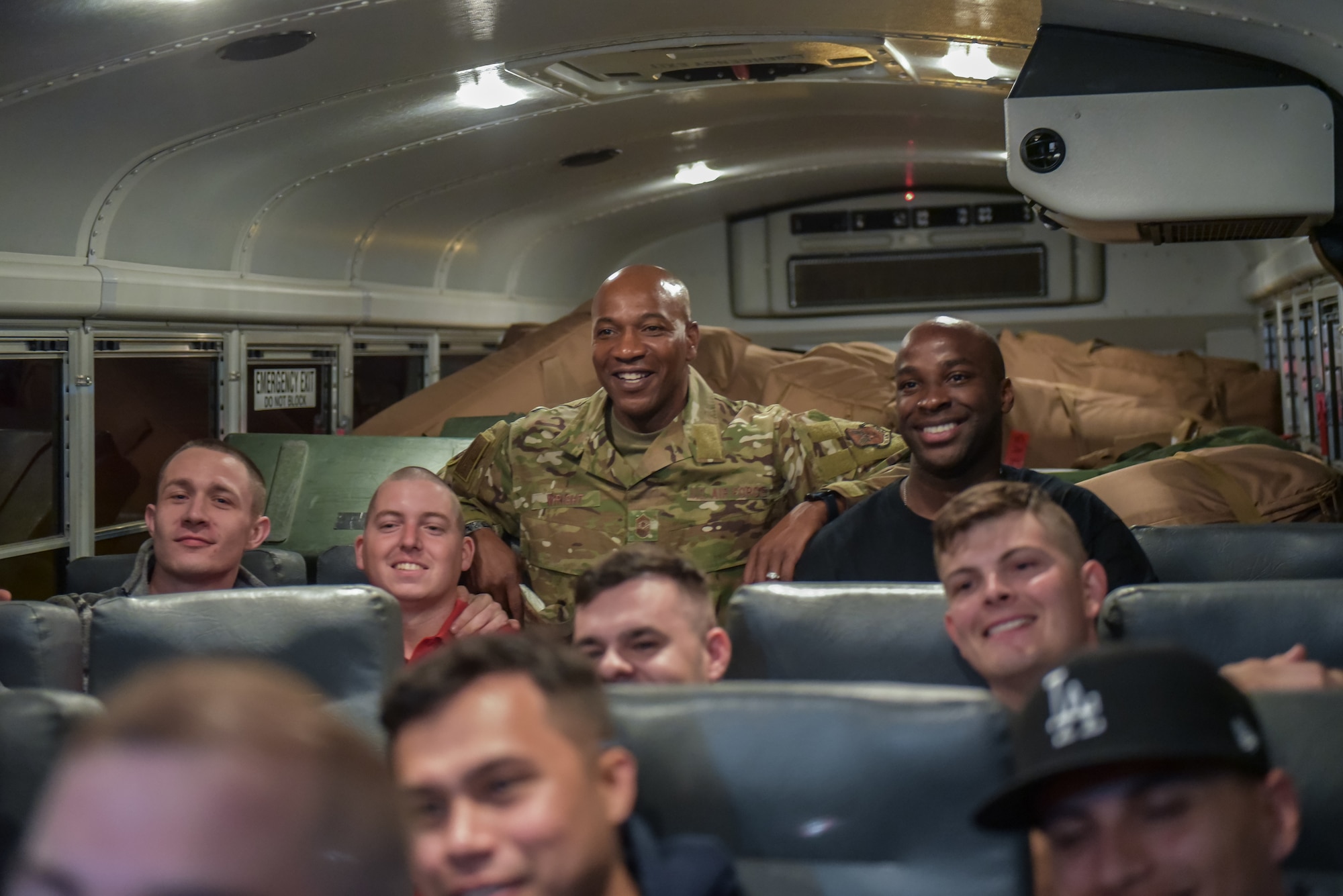 Chief Wright poses for a photo with a bus ful of Airmen