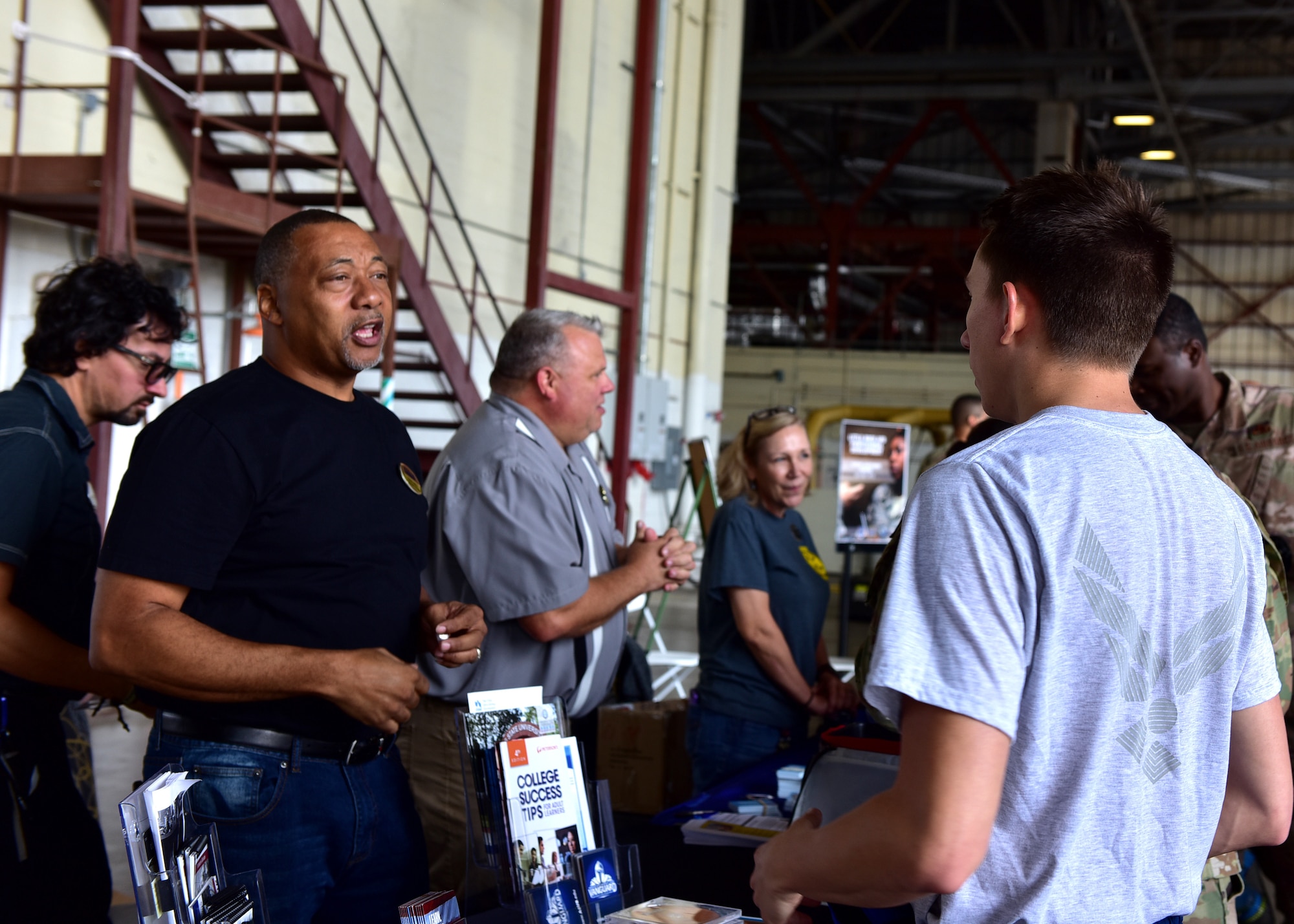 people talking duing mission expo inside hangar