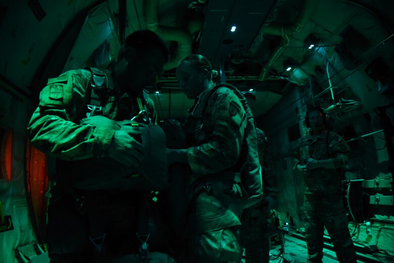 U.S. Army Staff Sgt. Dawn Davis, jumpmaster and acting airborne safety from the 4th Brigade Combat Team (Airborne), 25th Infantry Division, attaches equipment for U.S. Army Staff Sgt. Adam DeGroot, 4-25 IBCT jumpmaster, before his jump during the joint forces exercise called Arctic Anvil, Oct. 1-6, over Camp Shelby Joint Forces Training Center, Miss. Reserve Citizen Airmen from the 815th Airlift Squadron assigned to the 403rd Wing at Keesler Air Force Base, Miss., and the 327th AS assigned to the 913th Airlift Group at Little Rock AFB, Ark., provided airlift and airdrop capabilities during the exercise. (U.S. Air Force photo by Jessica L. Kendziorek)