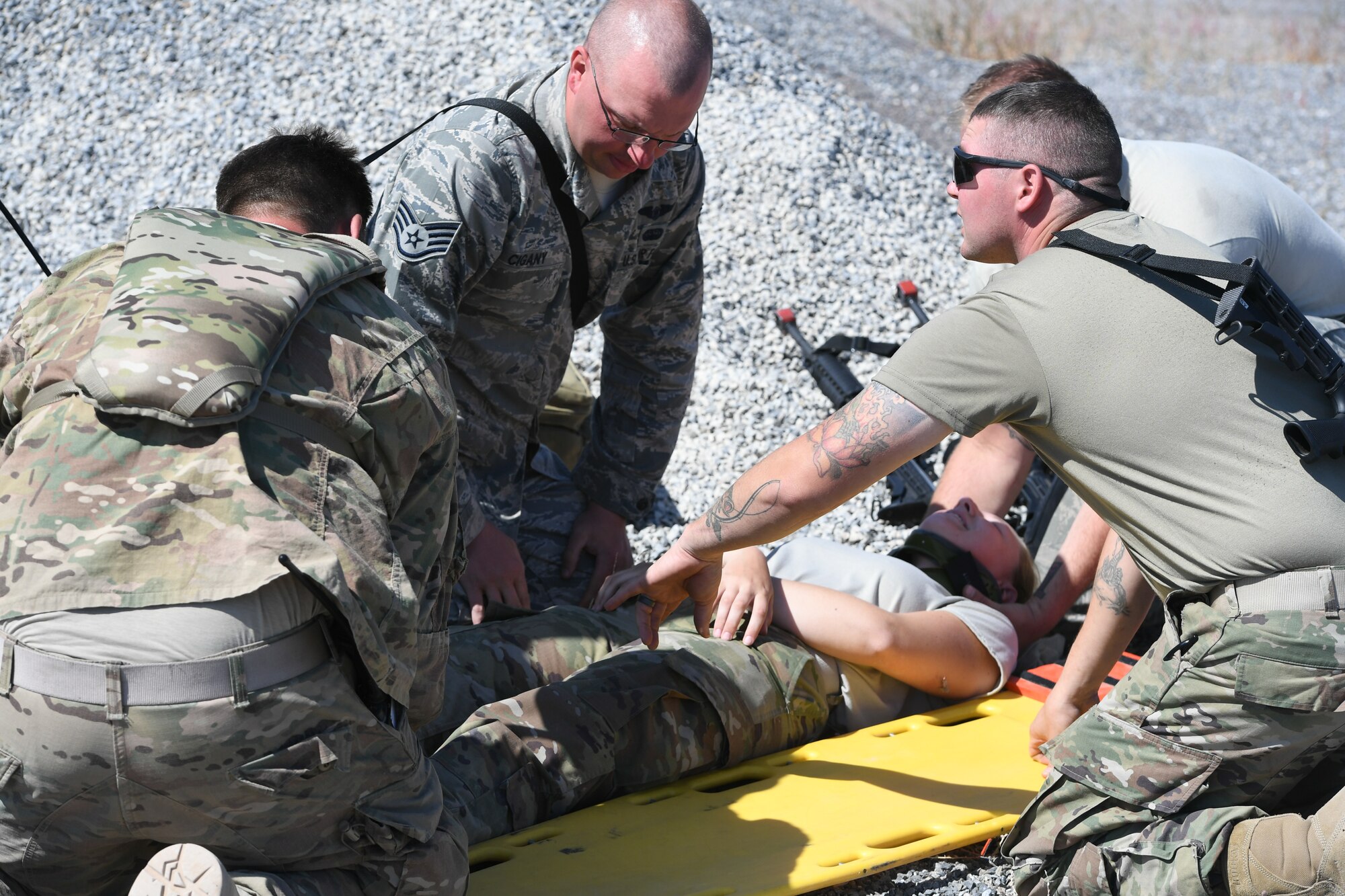Technical Sgt. Scott Ross (right), an independent duty medical technician attached to 729th Air Control Squadron, demonstrates how to move a simulated spinal injured Airman Sept. 23, 2019 during Self-Aid Buddy Care training at a base camp at Wendover Field, Utah. The Airmen were participating in the squadron’s annual Raging Bull exercise, where they set up a remote radar site to extend the unit's capability to control aircraft. (U.S. Air Force photo by Cynthia Griggs)