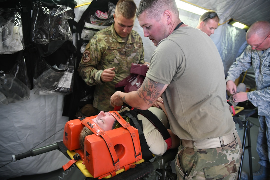 Airmen from 729th Air Control Squadron work together to aid a simulated spinal injured Airman Sept. 23, 2019, during Self-Aid Buddy Care training at a base camp at Wendover Field, Utah. The Airmen were participating in the squadron’s annual Raging Bull exercise, where they set up a remote radar site to extend the unit's capability to control aircraft. (U.S. Air Force photo by Cynthia Griggs)