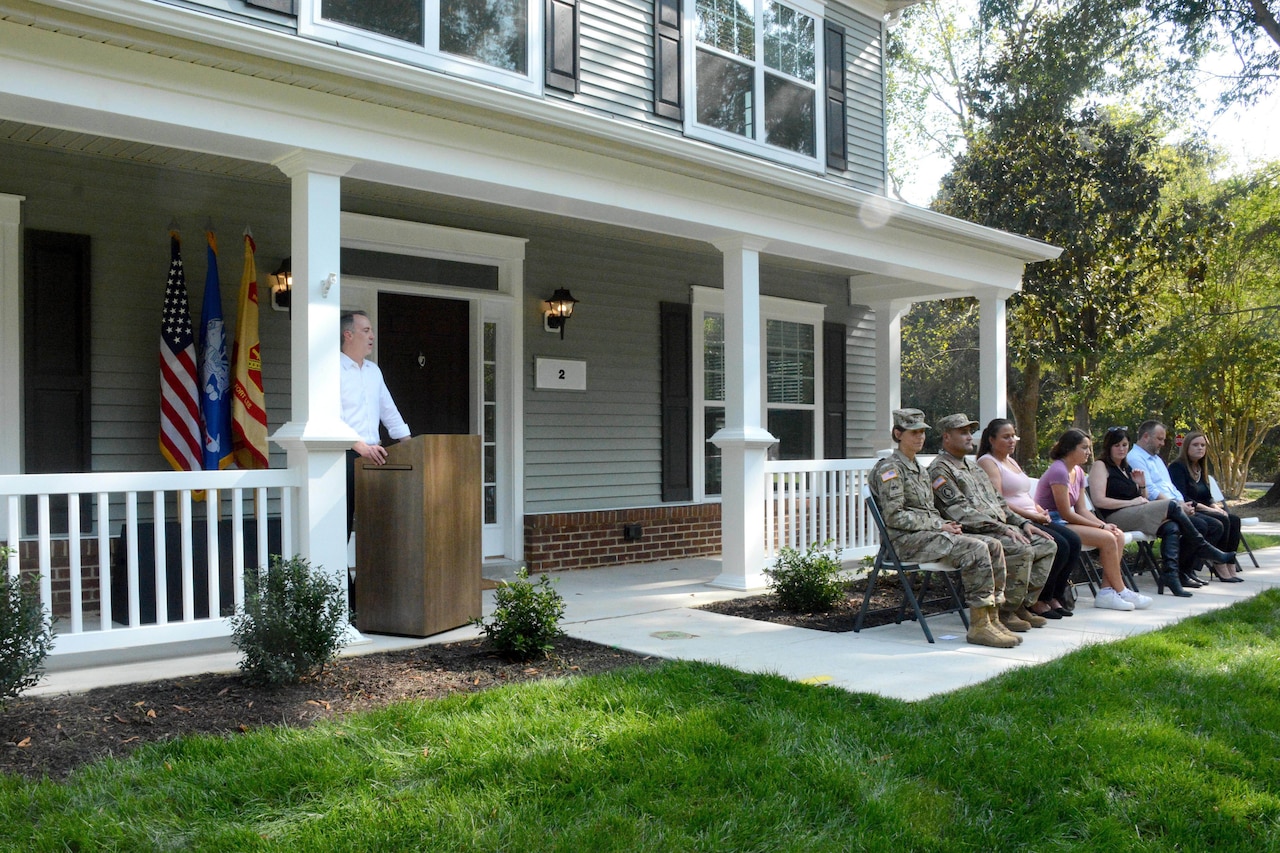 A man stands at a podium on a house porch.