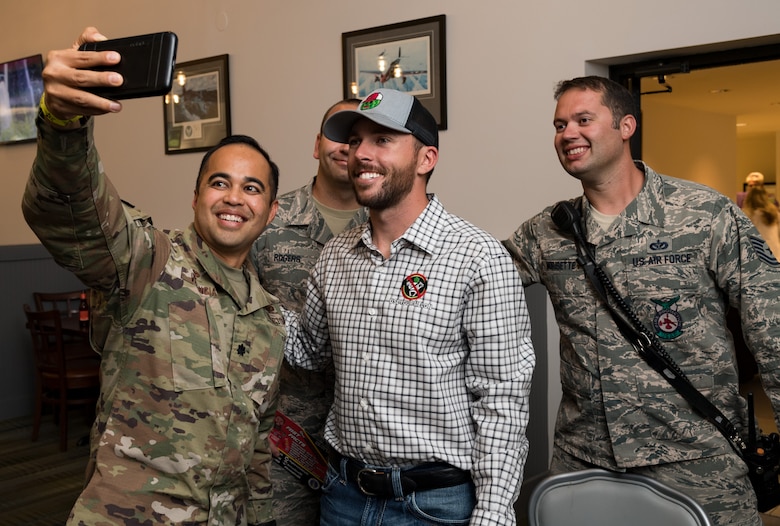 Lt. Col. Vhance Valencia, 436th Civil Engineer Squadron commander, takes a selfie with Ross Chastain, driver of the No. 15 Low-T Center Chevrolet Camaro, along with Tech. Sgt. Scott Morisette and Staff Sgt. Dustin Rogers, both from the 436th CES fire department Oct. 4, 2019, at Dover Air Force Base, Del. Chastain attended October's First Friday in Hangar 295 at The Landings to sign autographs and meet some of Team Dover's Airmen. He is scheduled to drive in the "Drydene 400" Monster Energy NASCAR Cup Series playoff race on Oct. 6, 2019. (U.S. Air Force photo by Roland Balik)
