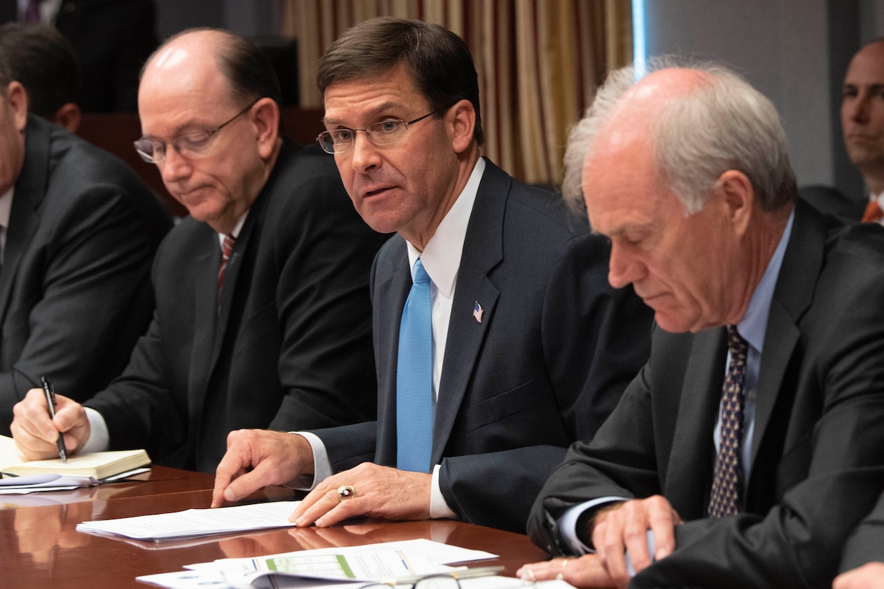 Defense Secretary Dr. Mark T. Esper sits at a table with other leaders.