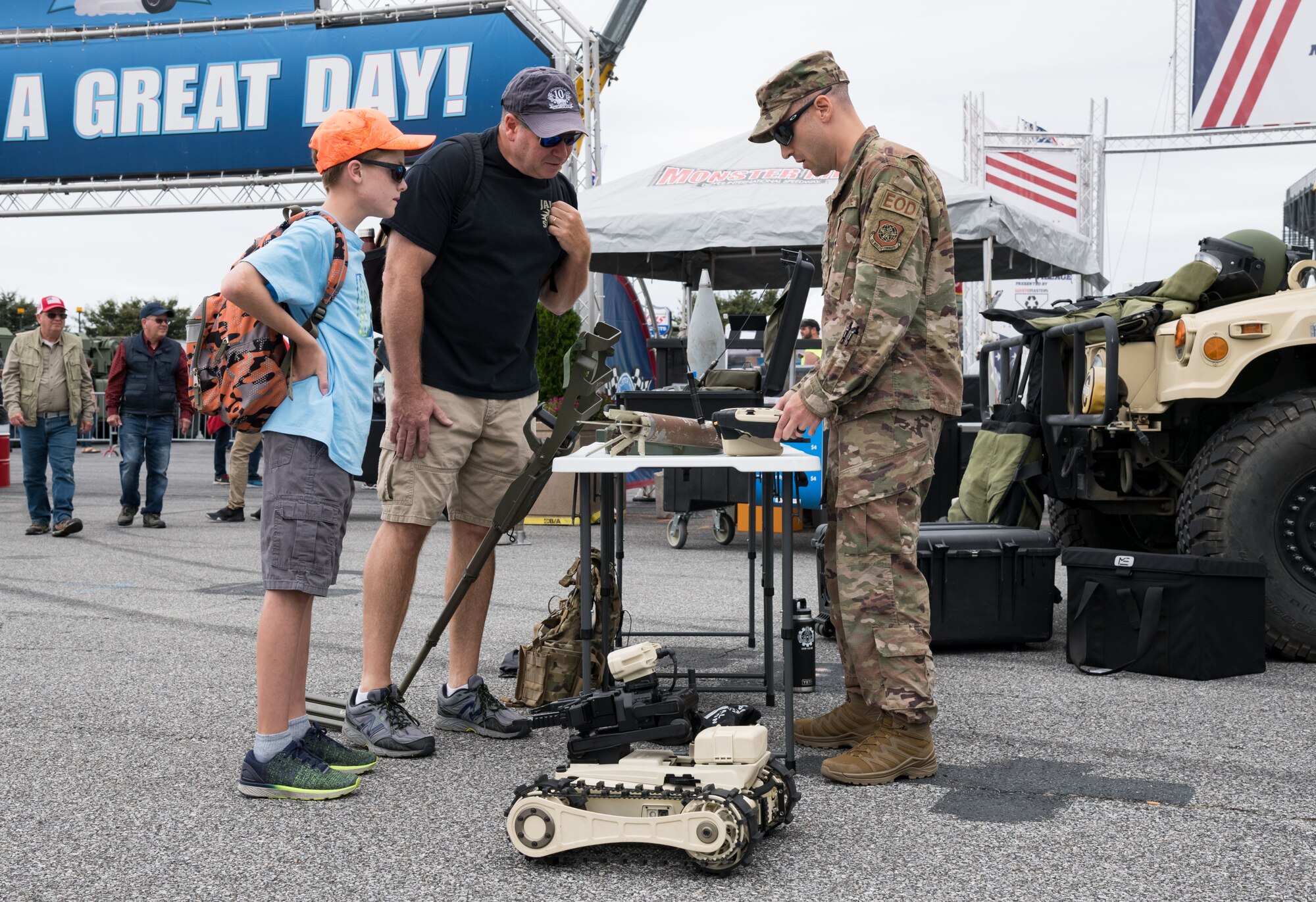 Staff Sgt. Andrew Vitale, 436th Civil Engineer Squadron explosive ordnance disposal craftsman, answers questions from race fans Oct. 6, 2019, at Dover International Speedway, Dover, Del. Members from the 436th CES EOD, Fire Department and 436th Security Forces Squadron set up equipment and vehicle static displays in the Monster Mile Youth Nation area. (U.S. Air Force photo by Roland Balik)