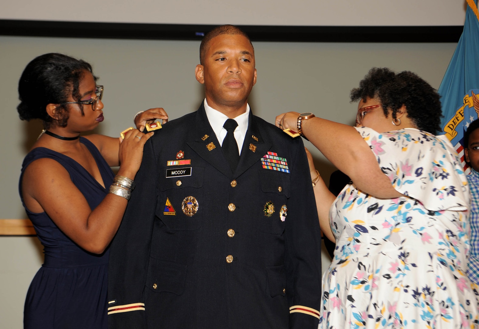 Daughter Maria McCoy, left, and wife, Bernice McCoy, right, place the new colonel rank on the shoulders of Army Col. Eric McCoy, center, during his promotion ceremony at DLA Troop Support in Philadelphia, Oct. 3, 2019. McCoy, a Baltimore native, is the Troop Support Subsistence supply chain director. (Photo by Ed Maldonado/DLA Troop Support)