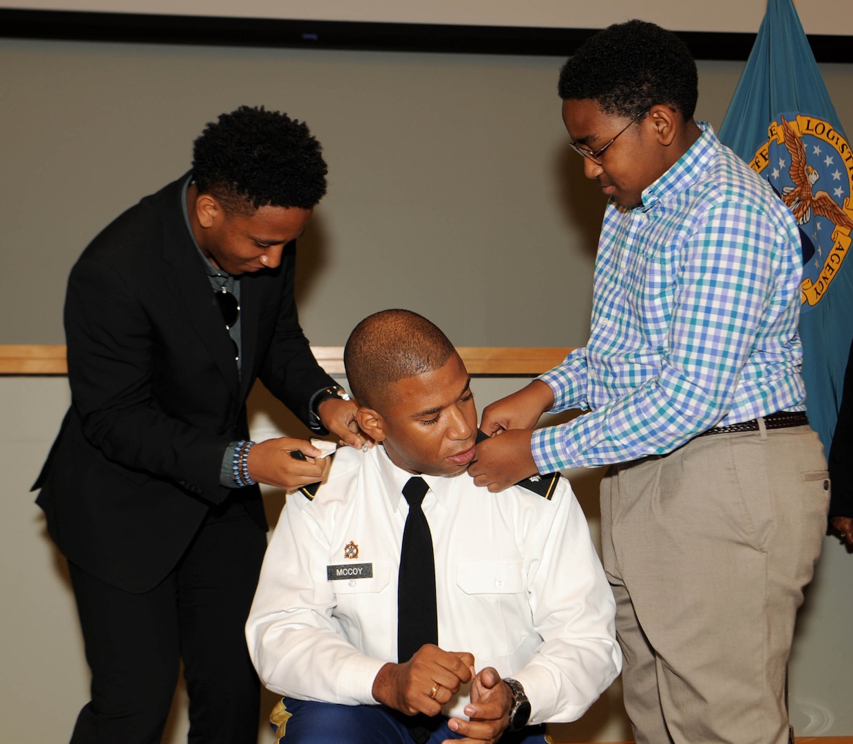 Sons, Solomon McCoy, left, and Joseph McCoy, right, place the new colonel rank on the shoulders of their father, Army Col. Eric McCoy, center, during his promotion ceremony at DLA Troop Support in Philadelphia, Oct. 3, 2019. McCoy, a Baltimore native, is the Troop Support Subsistence supply chain director. (Photo by Ed Maldonado/DLA Troop Support)