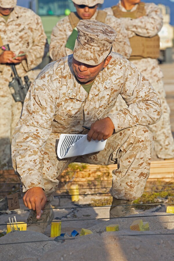 U.S. Marine Corps Staff Sgt. Diego Romero, a motor transport operations chief with Marine Wing Support Squadron (MWSS) 372, Marine Wing Support Group 37, 3rd Marine Aircraft Wing, gives a brief over a simulated terrain model in support of an aircraft salvage and recovery exercise during Weapons and Tactics Instructor (WTI) course 1-20 at Site 2 in Yuma Proving Ground, Arizona, Sept. 25, 2019. WTI is a seven-week training event hosted by Marine Aviation Weapons and Tactics Squadron One (MAWTS-1), which emphasizes operational integration of the six functions of Marine Corps aviation in support of a Marine Air Ground Task Force. MAWTS-1 also provides standardized advanced tactical training and certification of unit instructor qualifications to support Marine aviation training and readiness, and assists in developing and employing aviation weapons and tactics. (U.S. Marine Corps photo by Cpl. Ursula V. Smith)