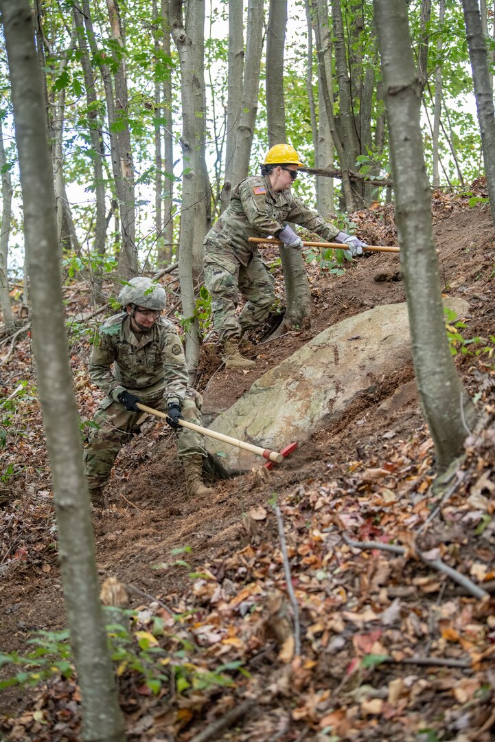 Two Soldiers of the West Virginia Army National Guard’s 249th Army Band clear  debris from a fireline during basic wildland fire suppression training, conducted by the West Virginia Division of Forestry in Morgantown, West Virginia, Oct. 3, 2019. The training covered basic wildland fire fighting techniques including understanding fire behavior, suppression tactics and techniques, crew organization, communications, and crew safety and awareness, with the goal of providing WNVG Soldiers the basic skills and experience to operate on a fire line side-by-side with experienced Division of Forestry personnel. (U.S. Army National Guard photo by Edwin L. Wriston)