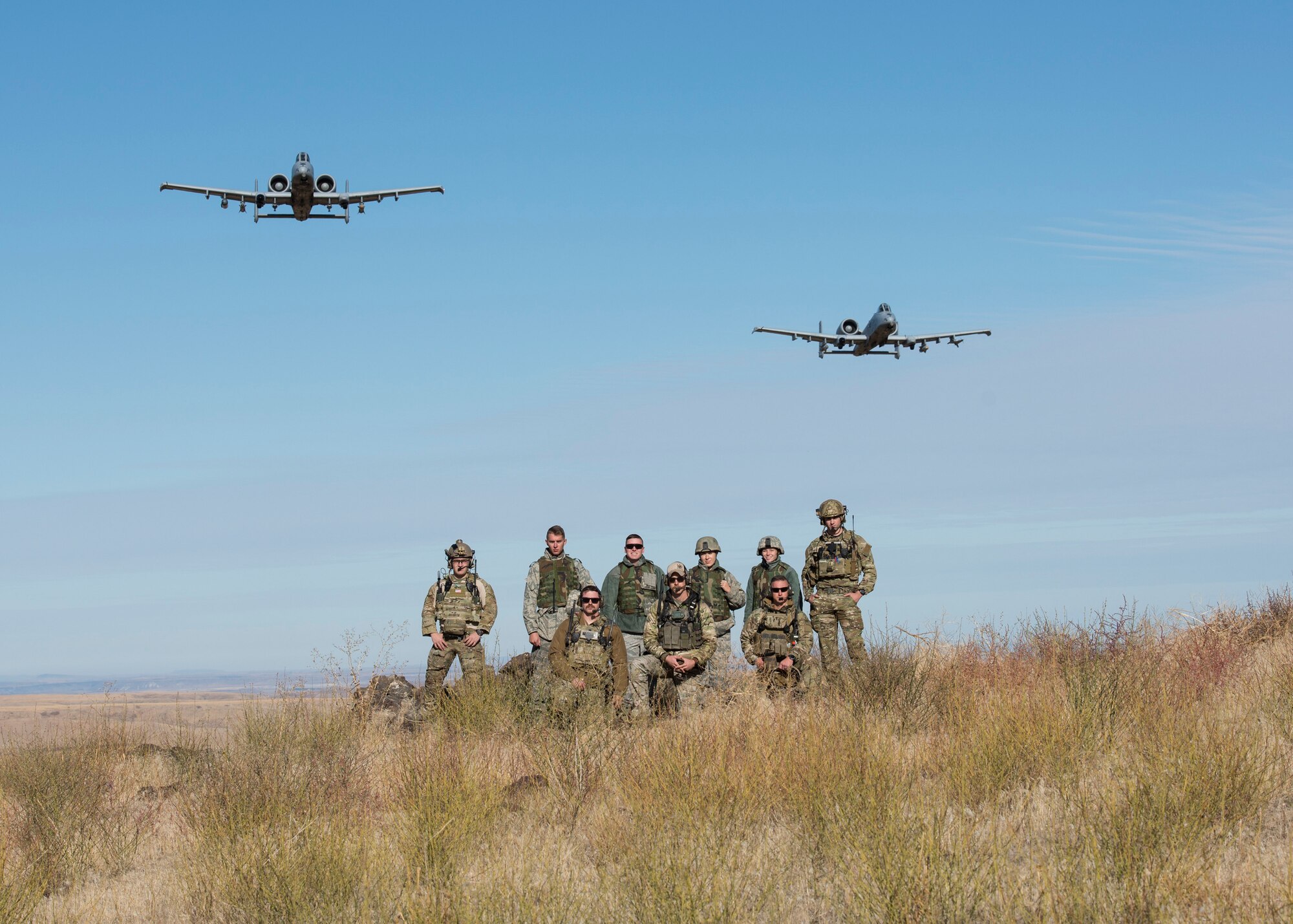 Two  A-10 Thunderbolt IIs, assigned to the 190th Fighter Squadron, fly over Airmen with the 124th Fighter Wing, Idaho Air National Guard, at the Saylor Creek Bombing Range, Idaho, Oct. 5, 2019. The range provides a designated area for pilots, Tactical Air Control Party Airmen and other mission-essential groups to run training missions. (U.S. Air National Guard photo by Airman 1st Class Taylor Walker)