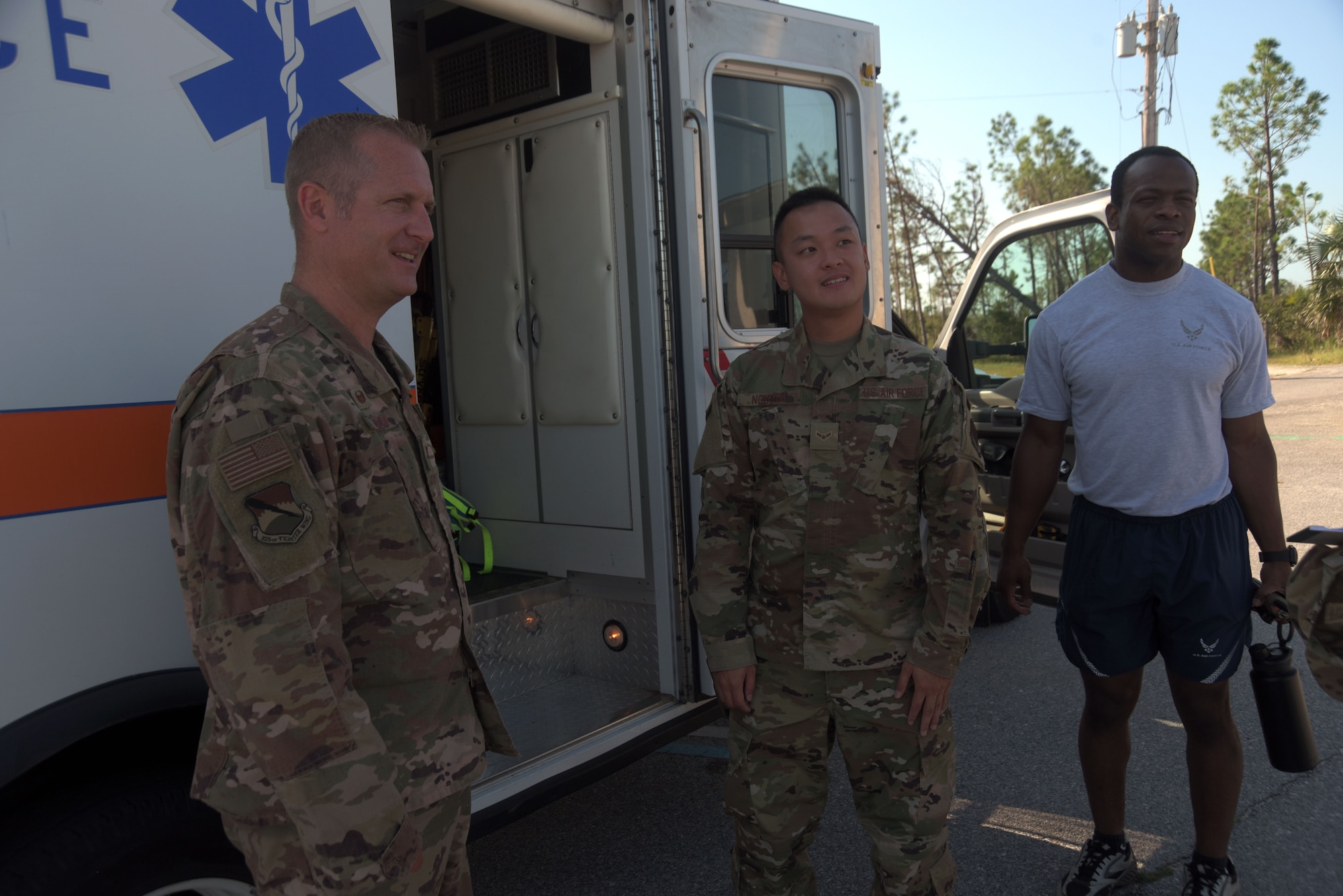 Col. Brian Laidlaw, 325th Fighter Wing commander, left, Airman 1st Class Brian Nguyen, center, and Senior Airman Zachary Collins, 325th Operational Medical Readiness Squadron Ambulance Services Department medics, have a discussion at a medical response exercise scene Oct. 4, 2019, at Tyndall Air Force Base, Florida. The squadron was chosen by the 325th Medical Group for the commander’s Airman Shadow Program, which aims to give the commander a first-hand view of what Airmen do on the job. (U.S. Air Force photo by Staff Sgt. Magen M. Reeves)