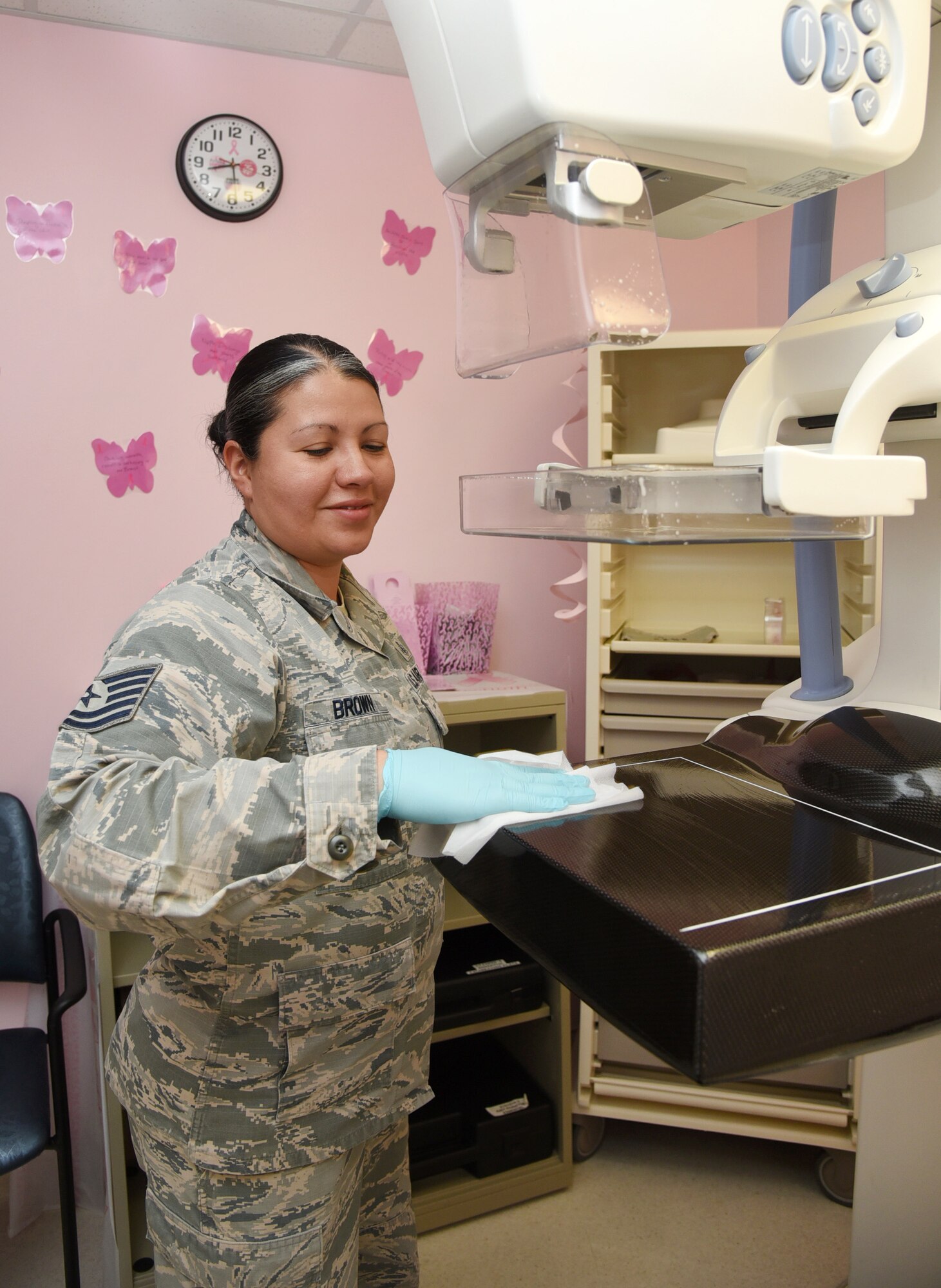 An image of a mammographer on base cleaning an imaging machine.