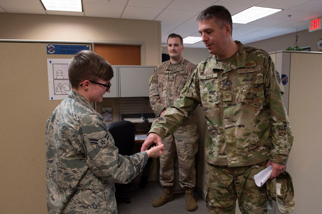 Col. Daniel Walls, right, 23d Wing commander, coins Airman 1st Class Taryn Butler, 23d Wing Public Affairs photojournalist, Oct. 7, 2019, at Moody Air Force Base, Ga. Butler was recognized for   producing a Resiliency Tactical Pause video that encompassed critical talking points from 23d Wing leadership and creating a video displaying the 23d Wing’s mission to care for its Airmen and families. Walls visited different components of Moody’s Wing Staff Agency to acknowledge their contributions to the mission. (U.S. Air Force photo by Airman Azaria E. Foster)