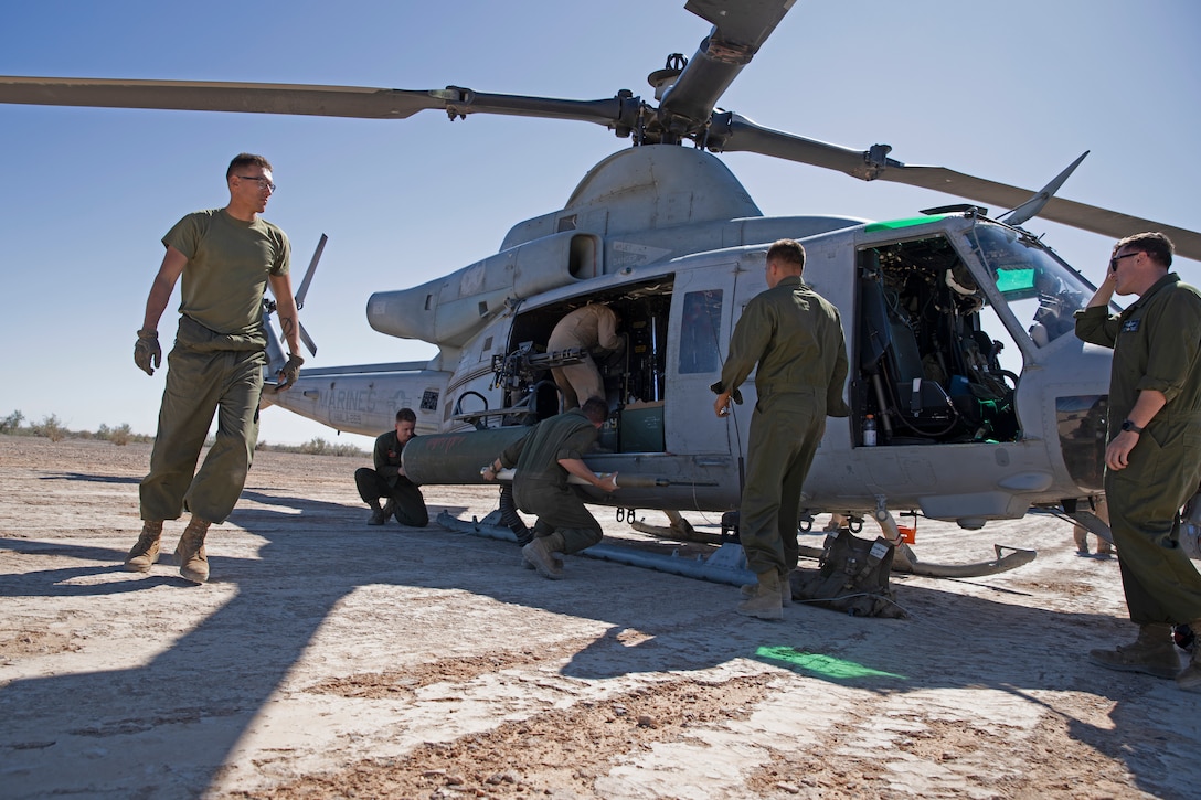 U.S. Marines with Marine Aviation Weapons and Tactics Squadron One (MAWTS-1) arm a UH-1Y Venom aircraft while conducting an offensive air support exercise during Weapons and Tactics Instructor (WTI) course 1-20 at Landing Zone Bull Attack in Chocolate Mountain Aerial Gunnery Range, California, Sept. 30, 2019. WTI is a seven-week training event hosted by MAWTS-1, which emphasizes operational integration of the six functions of Marine Corps aviation in support of a Marine Air Ground Task Force. WTI also provides standardized advanced tactical training and certification of unit instructor qualifications to support Marine aviation training and readiness, and assists in developing and employing aviation weapons and tactics. (U.S. Marine Corps photo by Cpl. Lauren Brune)