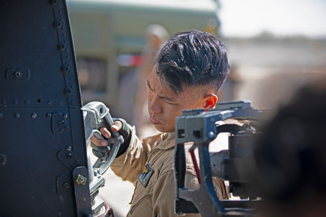 U.S. Marine Corps Cpl. William Ton, a UH-1Y Venom crew chief with Marine Light Attack Helicopter Squadron (HMLA) 469, Marine Aircraft Group 39, 3rd Marine Aircraft Wing, refuels a UH-1Y Venom aircraft while conducting an offensive air support exercise during Weapons and Tactics Instructor (WTI) course 1-20 at Landing Zone Bull Attack in Chocolate Mountain Aerial Gunnery Range, California, Sept. 30, 2019. WTI is a seven-week training event hosted by Marine Aviation Weapons and Tactics Squadron One (MAWTS-1), which emphasizes operational integration of the six functions of Marine Corps aviation in support of a Marine Air Ground Task Force. WTI also provides standardized advanced tactical training and certification of unit instructor qualifications to support Marine aviation training and readiness, and assists in developing and employing aviation weapons and tactics. (U.S. Marine Corps photo by Cpl. Lauren Brune)