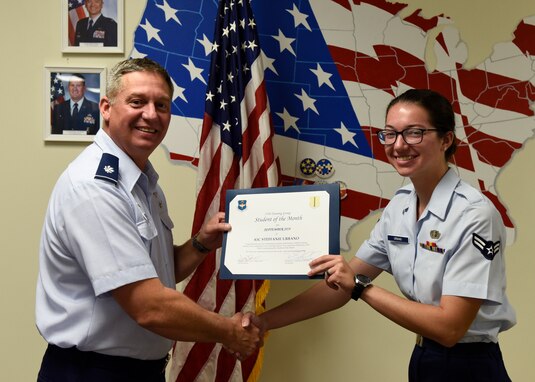 U.S. Air Force Lt. Col. Herbert Millet, 313th Training Squadron commander, presents the 316th Training Squadron Student of the Month award to Airman 1st Class Steffanie Urbano, 316th TRS student, at Brandenburg Hall on Goodfellow Air Force Base, Texas, Oct. 4, 2019. The 316th TRS’s mission is to conduct U.S. Air Force, U.S. Army, U.S. Marine Corps, U.S. Navy and U.S. Coast Guard cryptologic, human intelligence and military training. (U.S. Air Force photo by Airman 1st Class Zachary Chapman/Released)