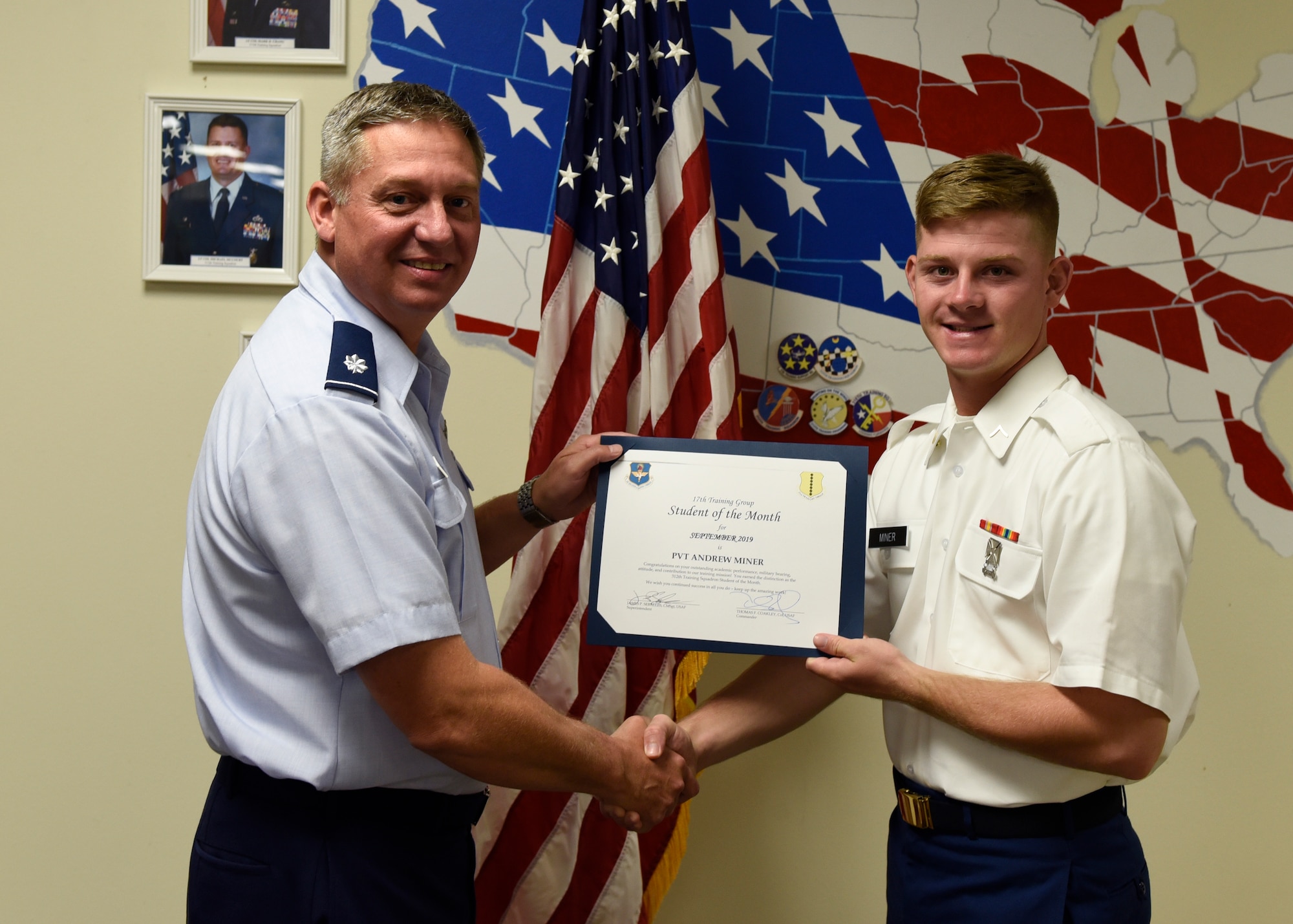 U.S. Air Force Lt. Col. Herbert Millet, 313th Training Squadron commander, presents the 312th Training Squadron Student of the Month award to U.S. Army Pvt. Andrew Miner, 312th TRS student, at Brandenburg Hall on Goodfellow Air Force Base, Texas, Oct. 4, 2019. The 312th TRS’s mission is to provide Department of Defense and international customers with mission-ready fire protection and special instruments graduates and provide mission support for the Air Force Technical Applications Center. (U.S.  Air Force photo by Airman 1st Class Zachary Chapman/Released)