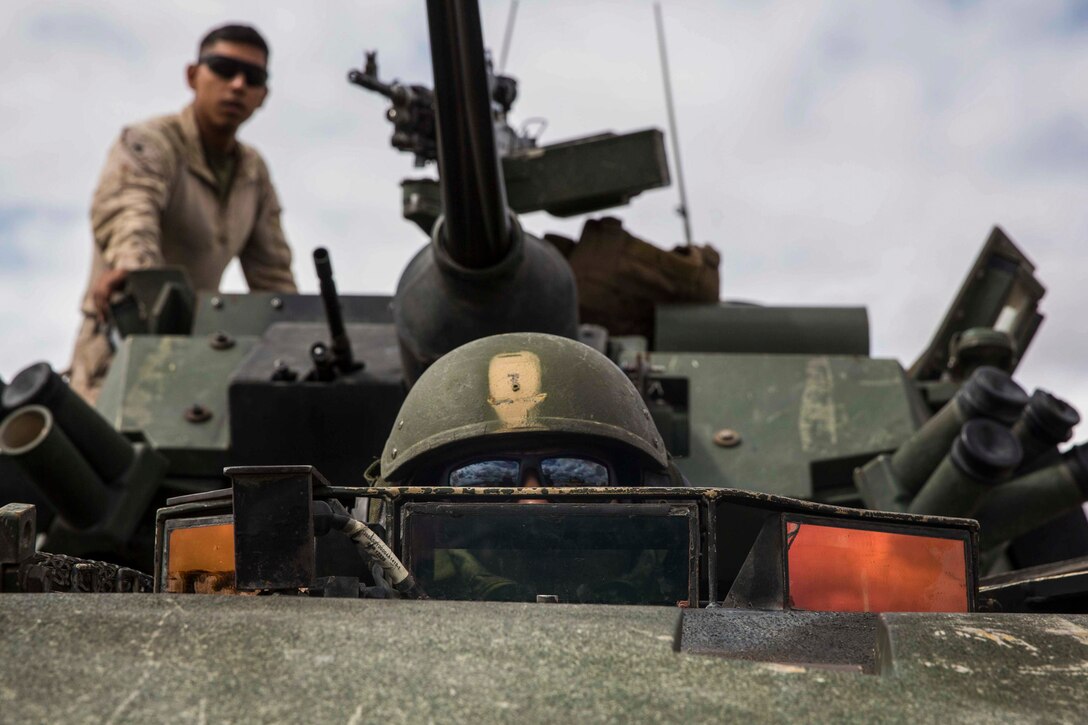 A Marine rides inside a military vehicle.