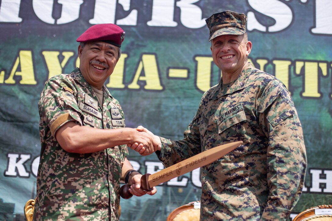 191005-M-EC058-1230 MALAYSIA (Oct. 05, 2019) Lt. Gen. Dato’ Suhaimi bin Hj Mohd Zuki (left), the Joint Force Commander of the Malaysian Armed Forces, receives a gift from Col. Fridrik Fridriksson, the commanding officer of the 11th Marine Expeditionary Unit, during the closing ceremony of Tiger Strike 2019 in Malaysia. Malaysian Armed Forces were joined by U.S. Marines and Sailors for exercise Tiger Strike 2019 where both forces participated in jungle survival, amphibious assault, aerial raids, and combat service support training and cultural exchanges. (U.S. Marine Corps photo by Cpl. Dalton S. Swanbeck)