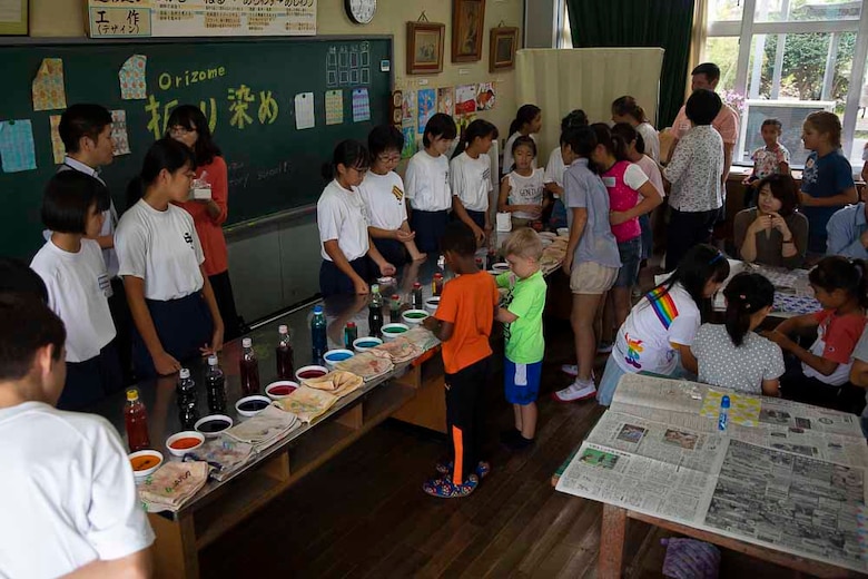 折り染めを体験するアメリカ人の児童。山口県岩国市立通津小学校で行われた地域文化交流に、岩国米海兵隊航空基地の隊員やその家族が参加し、美術工芸と料理のクラスが行われ、折り染めや餃子の作り方などを学びました。