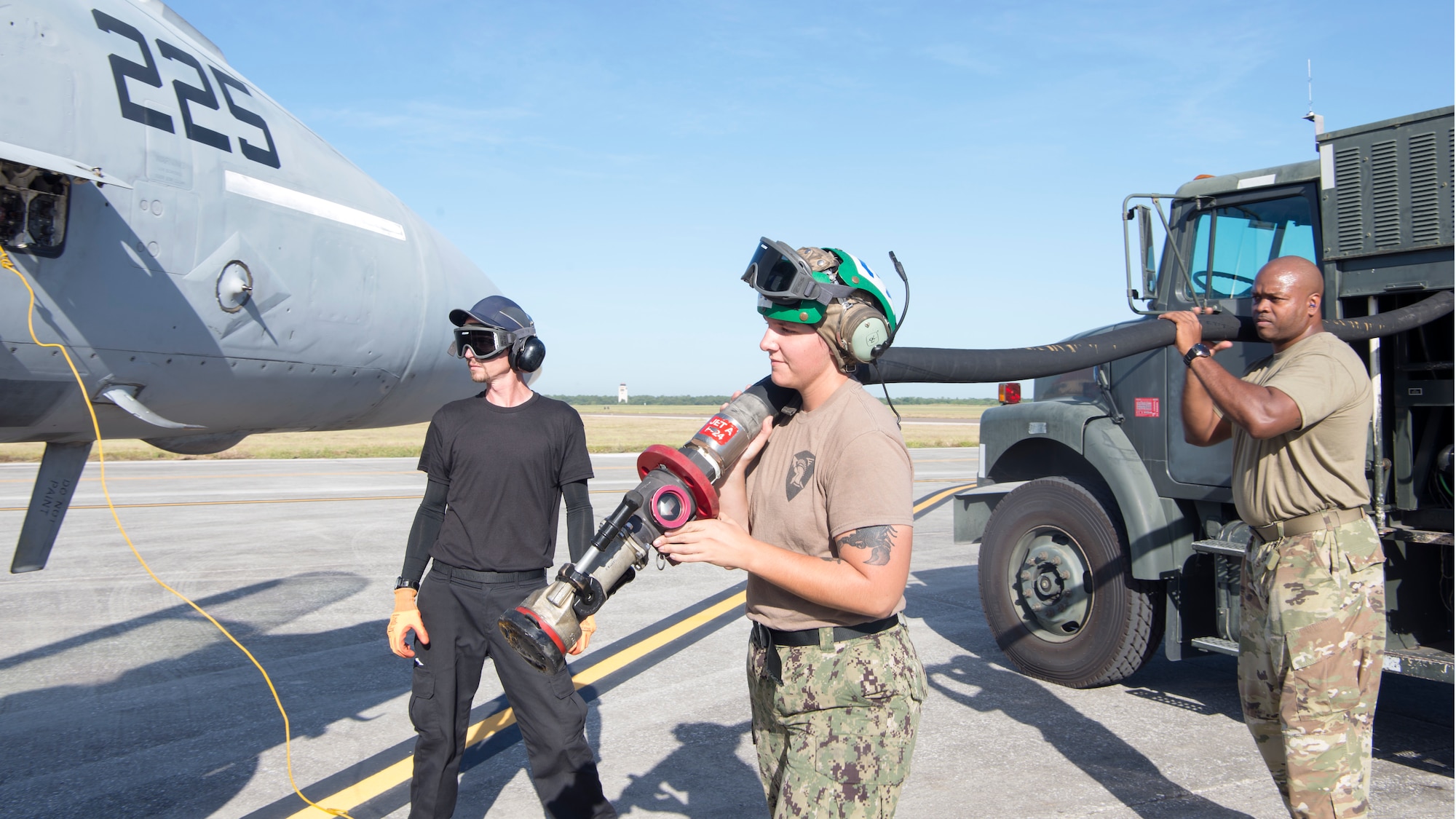 U.S. Navy aviation mechanics with the Strike Fighter Squadron (VFA) 106 from Naval Air Station Oceania, Va., and Tech. Sgt. Faelaun Onaolapo, right, a 6th Logistics Readiness Squadron petroleum, oil and lubricants NCO-in charge of fuels distribution, fuel a U.S. Navy F/A-18F Super Hornet aircraft from the VFA-106 at MacDill Air Force Base, Fla., Oct. 4, 2019.