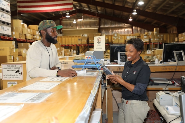 Logistics Management Specialist Jimmy Mapp orders supplies from Logistics Analyst Liz Johnson at a warehouse on Bagram Airfield, Afghanistan.  Mapp has worked for U.S. Army Corps of Engineers for six years and started his Afghanistan deployment as a 90-day assignment. He is now on his 10th month in country and has been promoted to a new job working in Information Technology for the Afghanistan District as a Contracting Officer Representative.