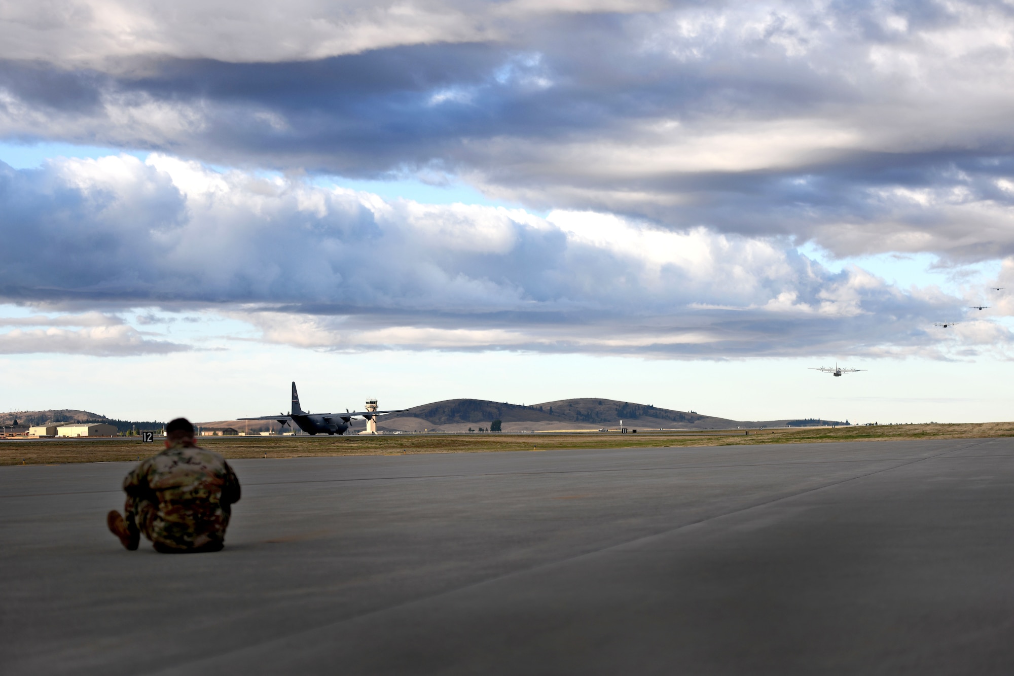 A man watches C-130s take off.