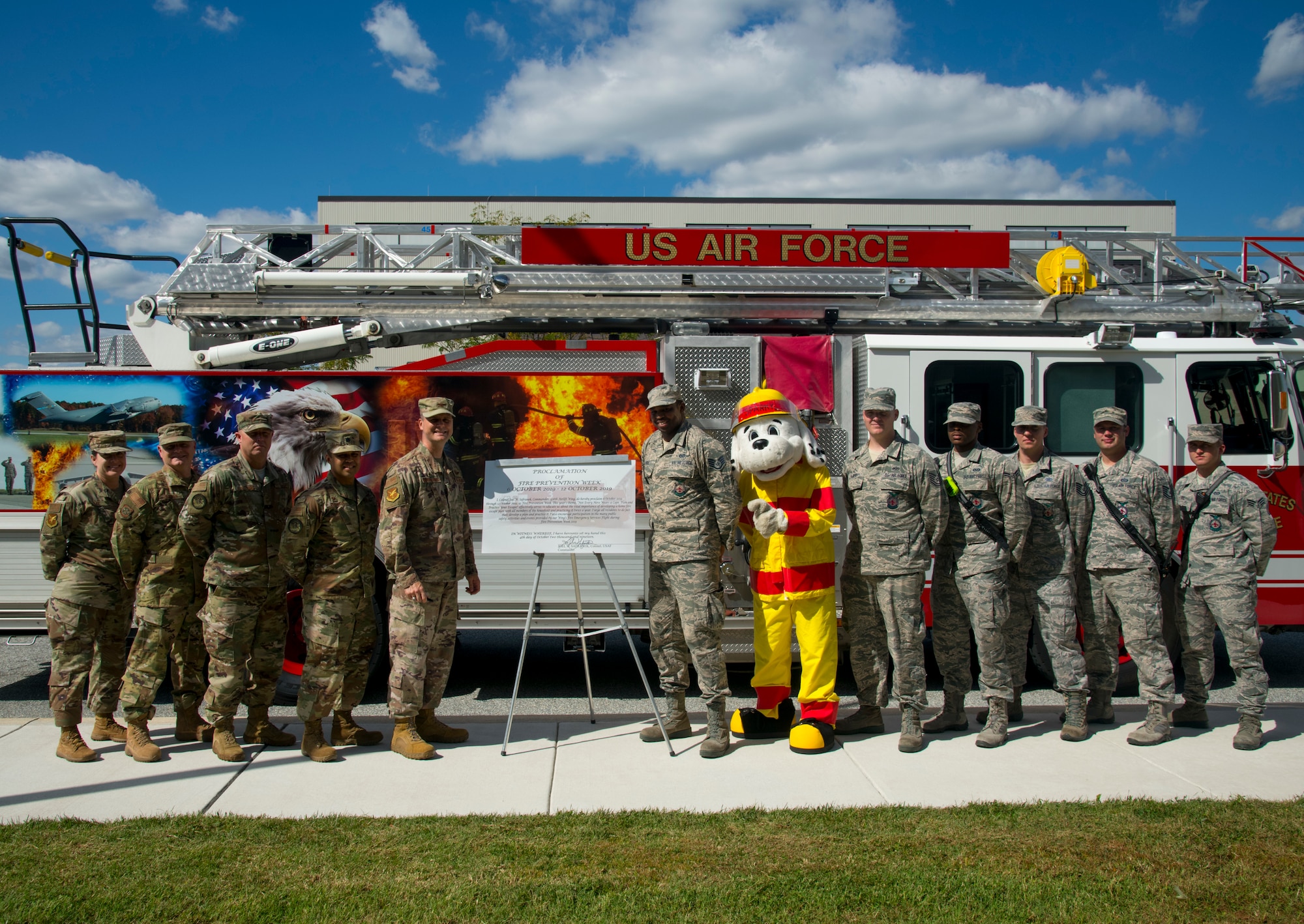 Members of the 436th Airlift Wing leadership team and the 436th Civil Engineer Squadron fire department pose next to the recently signed proclamation declaring, "October 6-12, 2019, Fire Prevention Week," Oct. 4, 2019, at Dover Air Force Base, Del. This year's theme, "Not Every Hero Wears a Cape. Plan and Practice Your Escape!" serves to educate the Dover AFB community about the importance of developing a home fire safety plan. (U.S. Air Force photo by Staff Sgt. Zoe Russell)