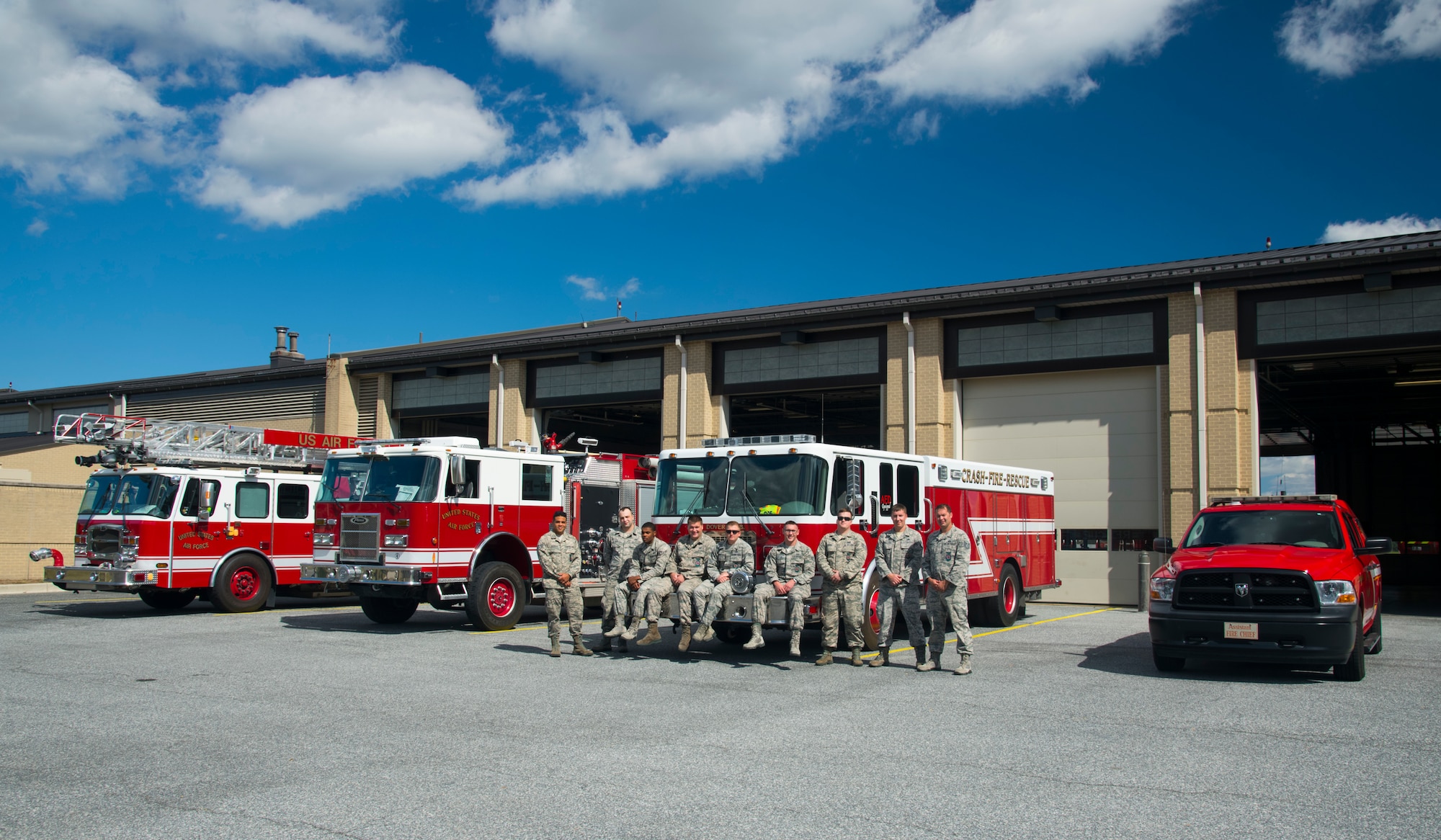 Members of the 436th Civil Engineer Squadron fire department pose next to their fire trucks Oct. 4, 2019, at Dover Air Force Base, Del. The firefighters were preparing for the upcoming Fire Prevention Week 2019, an annual weeklong observance to educate Dover AFB's community about the importance of fire prevention. (U.S. Air Force photo by Staff Sgt. Zoe Russell)