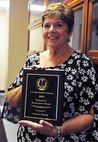 Gail Fisher poses with her U.S. Army Materiel Command Paralegal of the Year Award.
