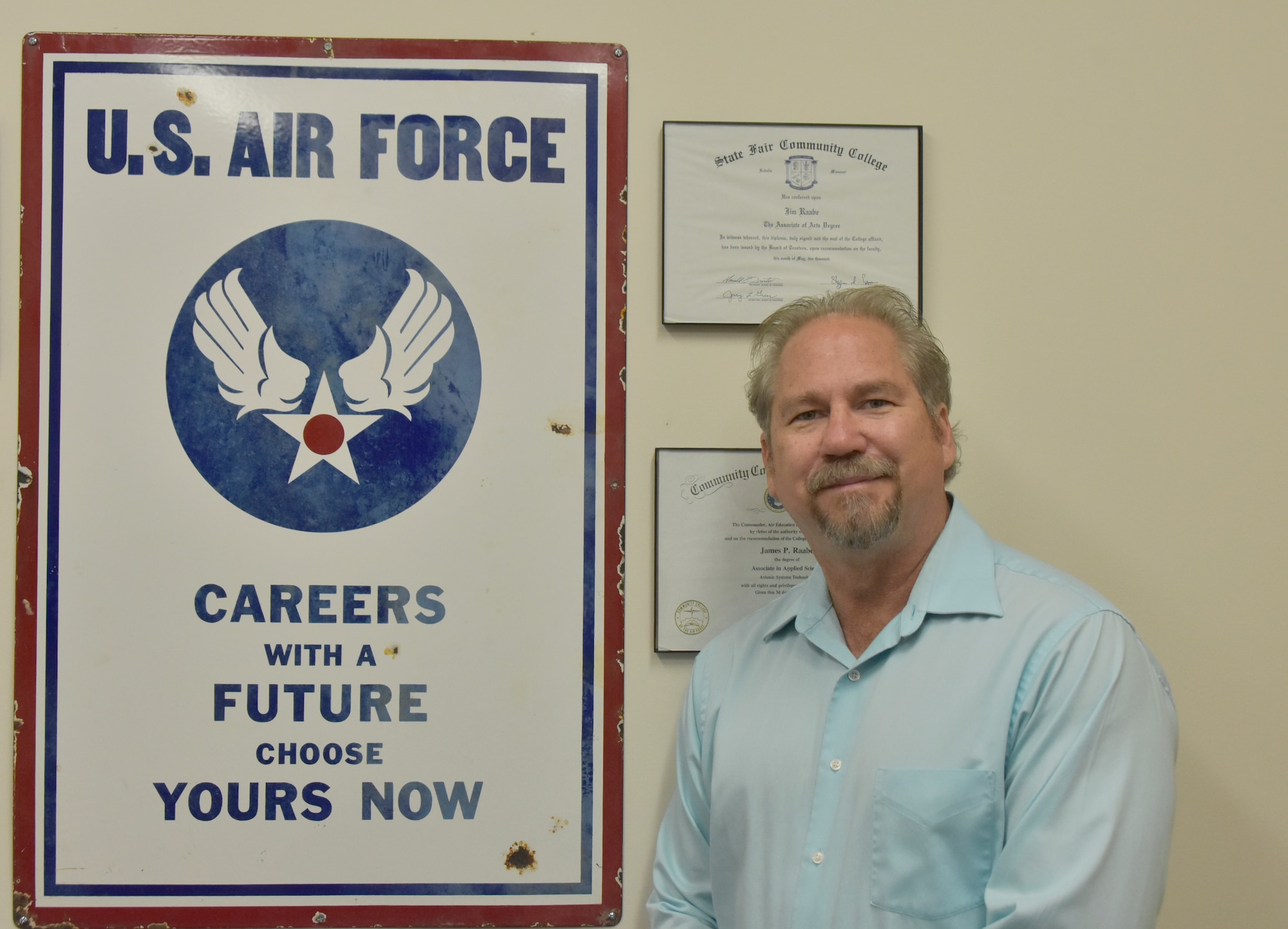 Capital Improvements Branch Systems Safety Program manager at Arnold Air Force Base, stands by an Air Force recruitment sign from the 1940s he acquired while antiquing, which has been an interest of his for nearly 40 years. The sign has been displayed in every office Raabe has had since purchasing it. (U.S. Air Force photo by Bradley Hicks)