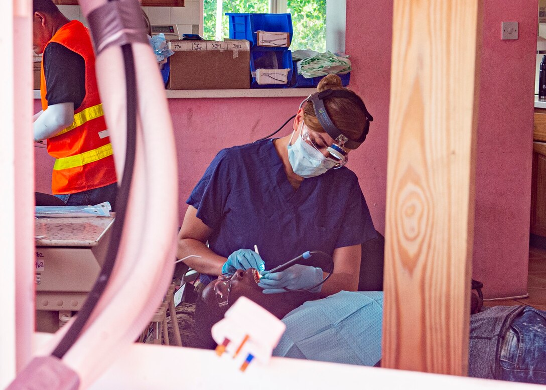 A dental technician cleans the teeth of a patient.